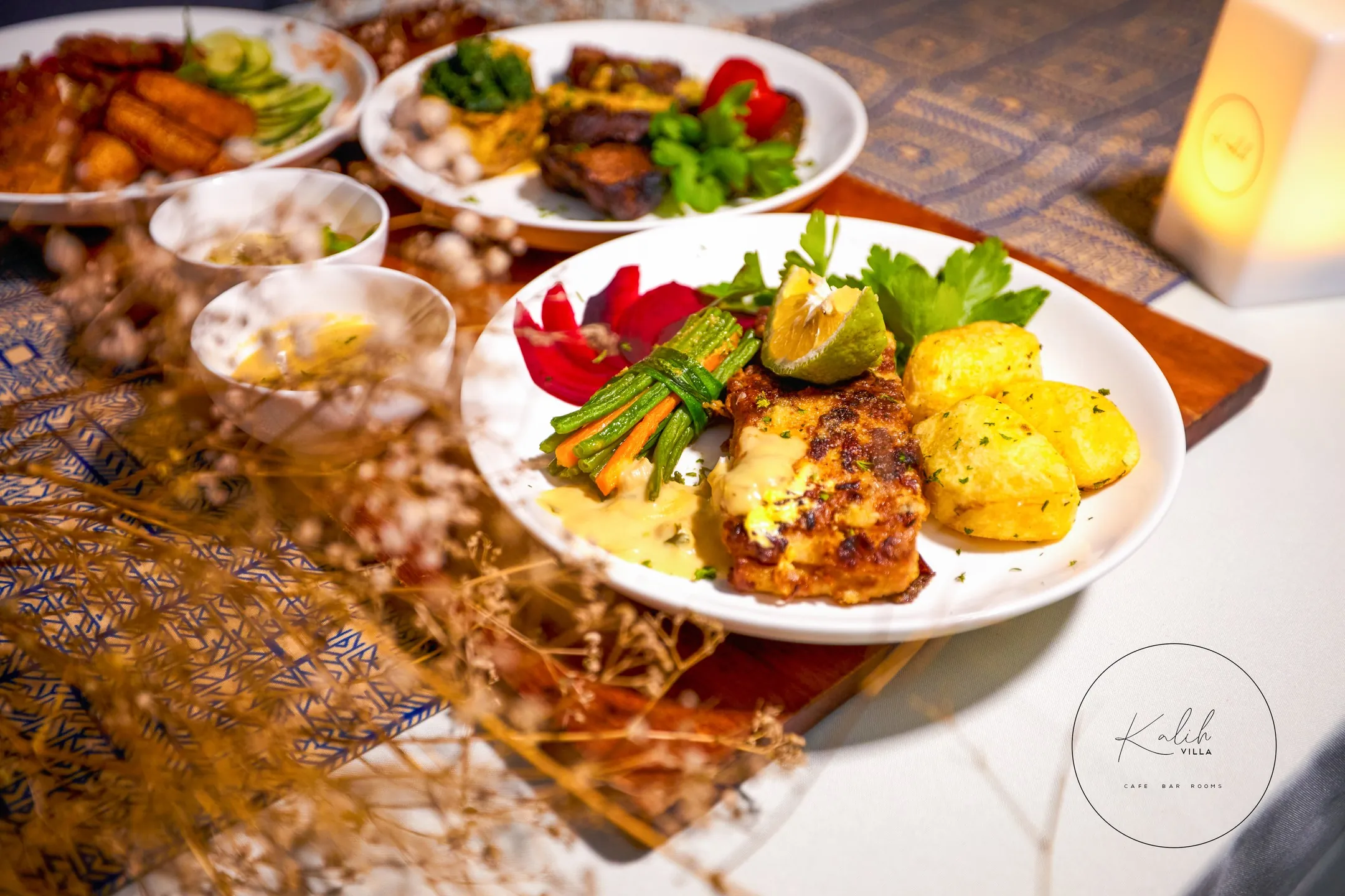 A spread of brochettes, rice, plantain and vegetables laid out on a table at Kalih Villa